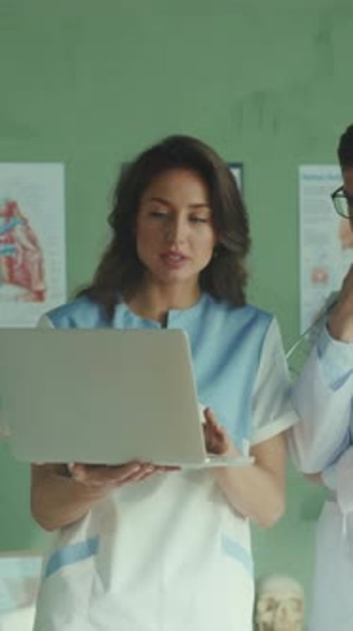 Female and Male Doctors Reviewing Laptop Information