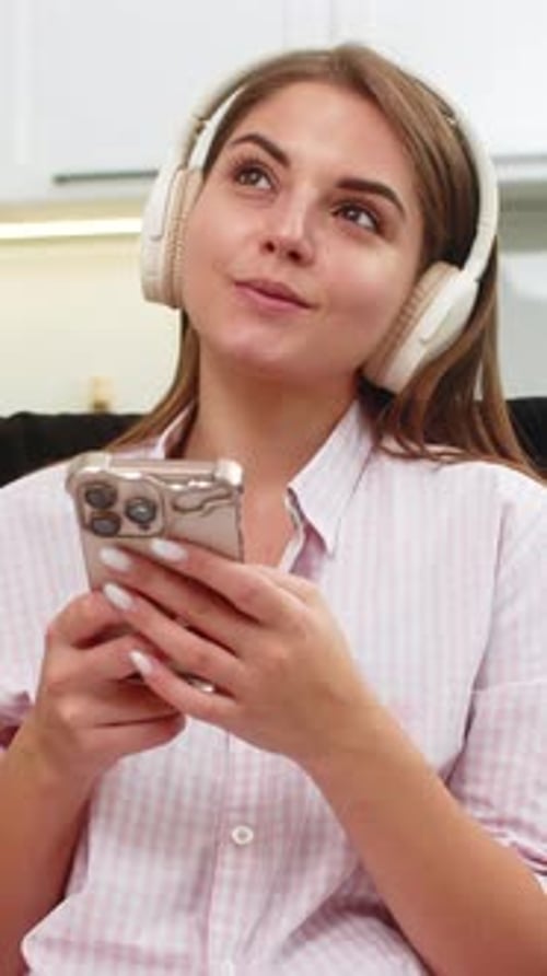 Woman Listens to Music Indoors with Phone