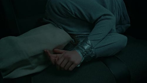 Un otage anonyme avec un sac sur la tête et les mains liées gisant dans une voiture