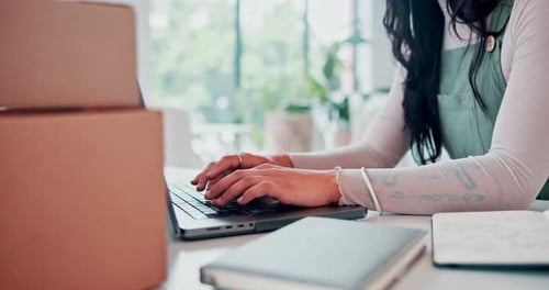 Business woman, typing or laptop by boxes in store, email or internet connection on online shop