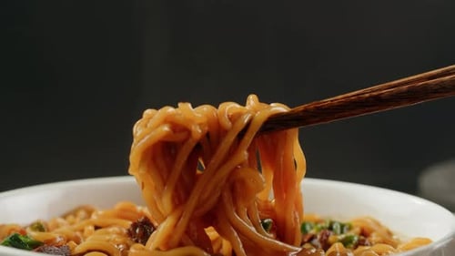 Close-Up of Steaming Noodles Being Lifted by Chopsticks