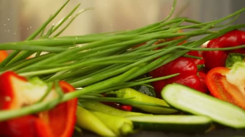 Wet Green Onions Fall on the Vegetables Forming Splashes