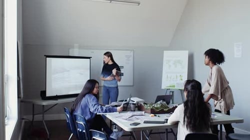 Environmental scientists collaborating on topographic maps in office meeting