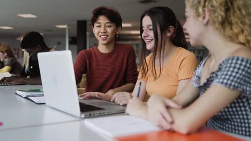 Young multiracial people studying together inside university library - School education concept
