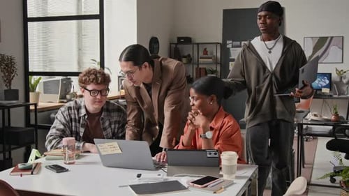 Multiethnische Entwickler arbeiten im modernen Büro am Laptop zusammen