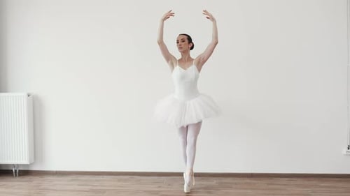 Elegant Ballerina Dancing in White Tutu in Studio