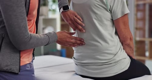 Healthcare Professional Examining an Adult Patient's Back