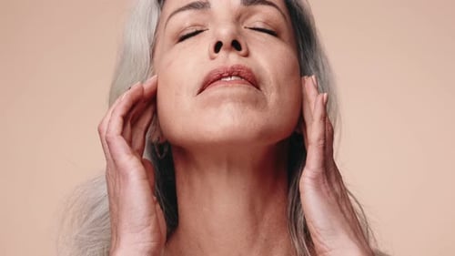 Woman Gently Massaging Face in a Close Up Shot