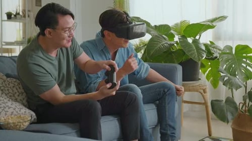 Young smiling gay couple playing video games