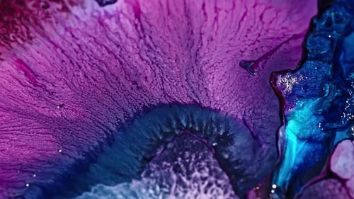 Close-up of vibrant purple and blue ink diffusing in water, creating an abstract pattern