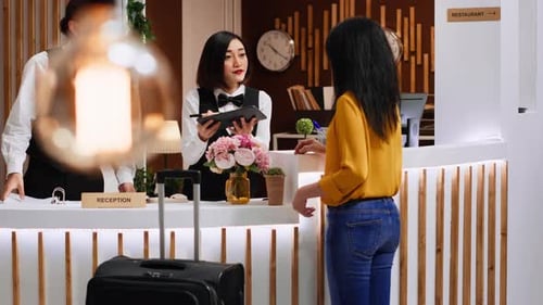 Hotel Guest Signing for Room Registration on Tablet at Front Desk