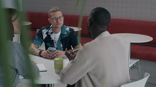 Three Colleagues Having Meeting in Cafe