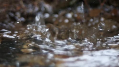 Water running into a drainage ditch,slow motion and close up