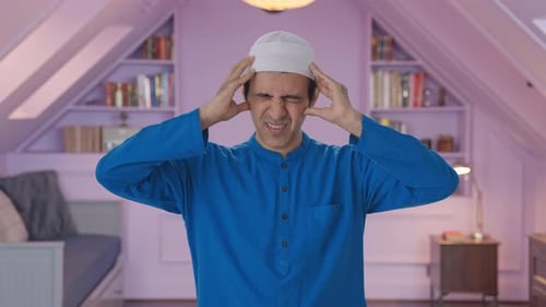 Adult with Headache Rubbing Forehead Indoors