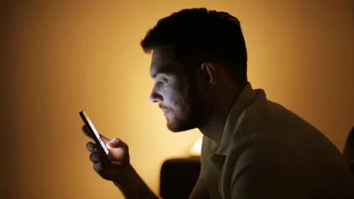 Technology, Internet, Communication and People Concept - Young Man Texting on Smartphone