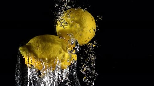 Lemons Dropping Into Water Close Up