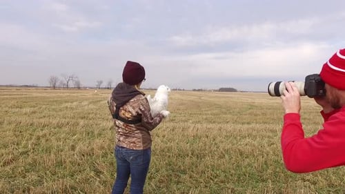 Woman Holding Owl As Photographer Takes Pictures