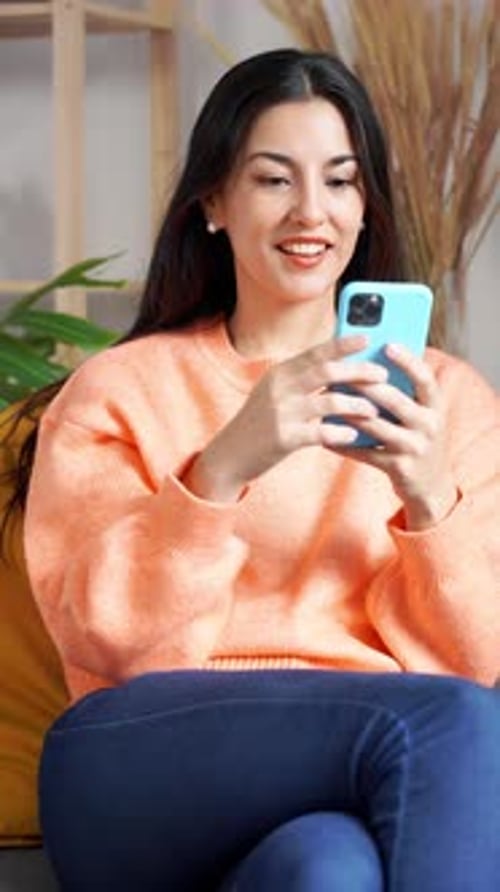 Woman Using Mobile Phone at Home