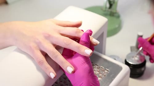 Woman Getting a Manicure in Pink Gloves