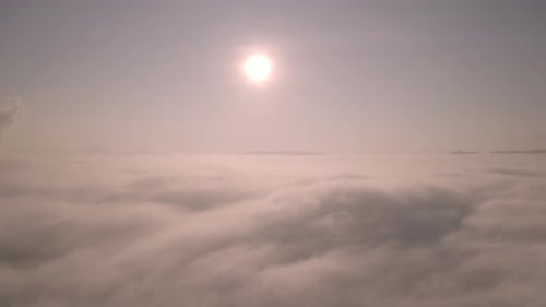 Video from a drone flying through fog and cloud layers. At the top, above the fog,
