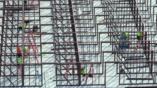 Bauarbeiten an Metallwänden von Büroarbeitern eines Geschäftshauses auf einer großen Baustelle mit