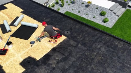 Roofer Installing Membrane on Flat Roof in Residential Area on Sunny Day