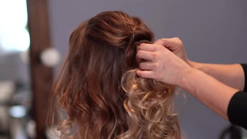 Girl Hairdresser Doing Hairstyle in the Form of Spinning Hair