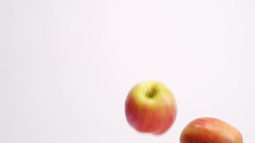 Red and Yellow Apples Floating Against White Background