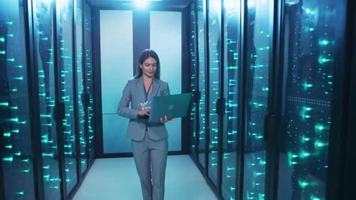 Eine professionelle Frau navigiert durch einen Serverraum und zeigt ihr technisches Fachwissen