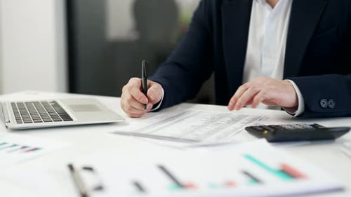 Close up. Man's hand fills out a form documents with a pen at a desk at a workplace in a business