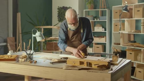 Man Sanding Wood in his Workshop