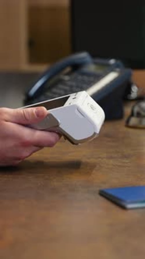 Guest Paying with Contactless Card at Hotel Reception Desk