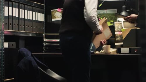 Investigators Analyzing Evidence in a Dark Office