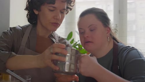 Two Women Prepare Food in Sunny Kitchen Together