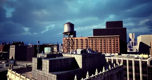 Horizonte urbano con torre de agua en medio de edificios modernos y cielo nublado