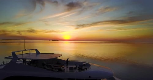 Aerial view of a yacht at sunset in the middle of the pristine sea. Concept of: holidays, luxury,