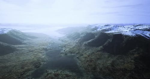 Expansive Landscape View of Mountain Range and Valley Under Cloudy Sky