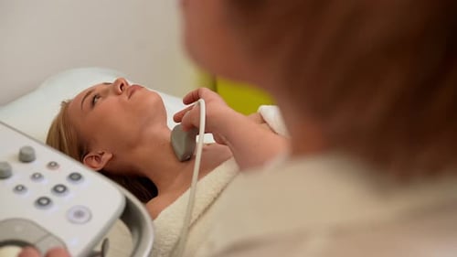 View From Shoulder of Unrecognizable Female Doctor in Modern Diagnostic Clinic Examining Thyroid
