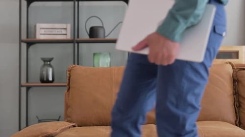 Man Working On Silver Laptop At Home On Couch