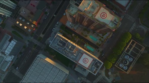 Top-down aerial view of downtown Los Angeles, showcasing rooftops and streets with car traffic, emph