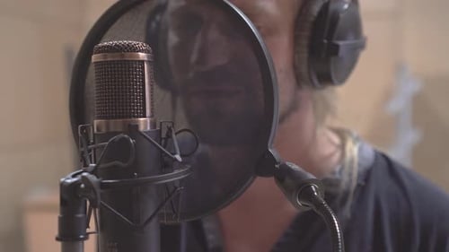 Man Sings Into Microphone in Recording Studio