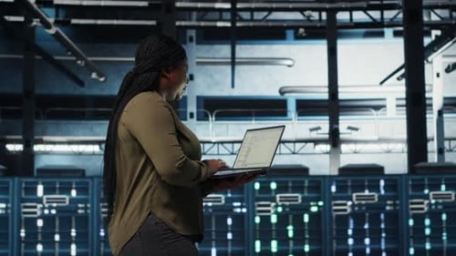 Desenvolvedor de software em data center usando laptop para implantar nova arquitetura de servidor