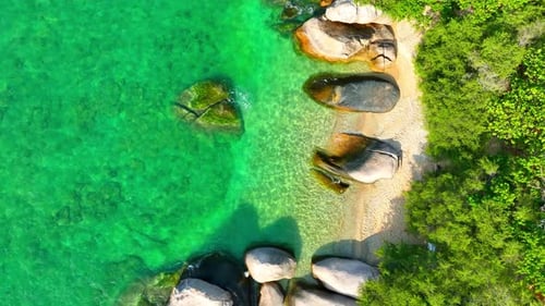 Stunning sandy beach with rock, clean sea water and green forest. 4K.