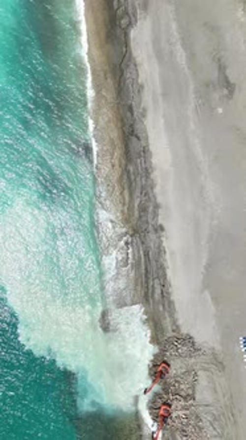 Vertical Video Carving the Coastal Beauty Aerial Exploration of Heavy Machinery's Work
