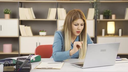 Woman Working on Laptop at Desk in Office