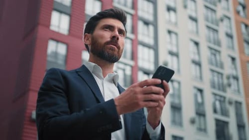 Caucasian Bearded Man Entrepreneur Businessman Hold Cellphone Texting Messages Stand in City with