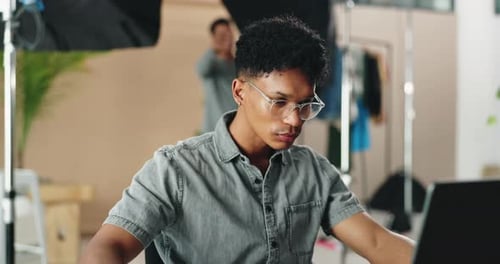 Young Adult Works on Laptop in Modern Office
