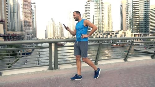 Sporty Man Texting on Smartphone While Walking on Bridge Super