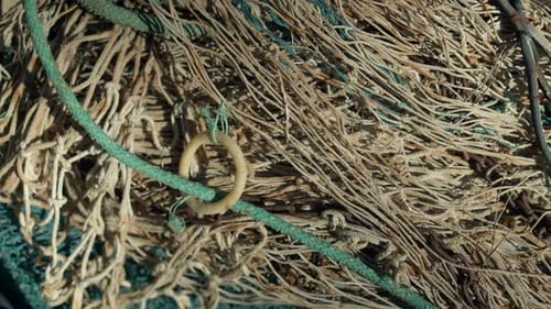 Close shot of piled and entangled fishing nets in a boat.