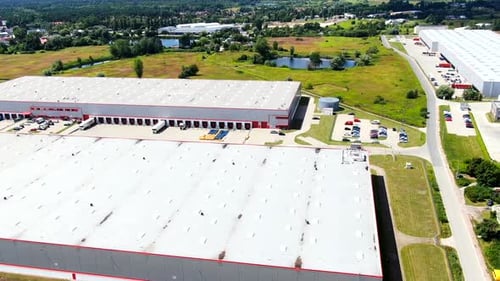 Aerial Shot of Truck with Attached Semi Trailer Leaving Industrial Warehouse Storage Building Loadin